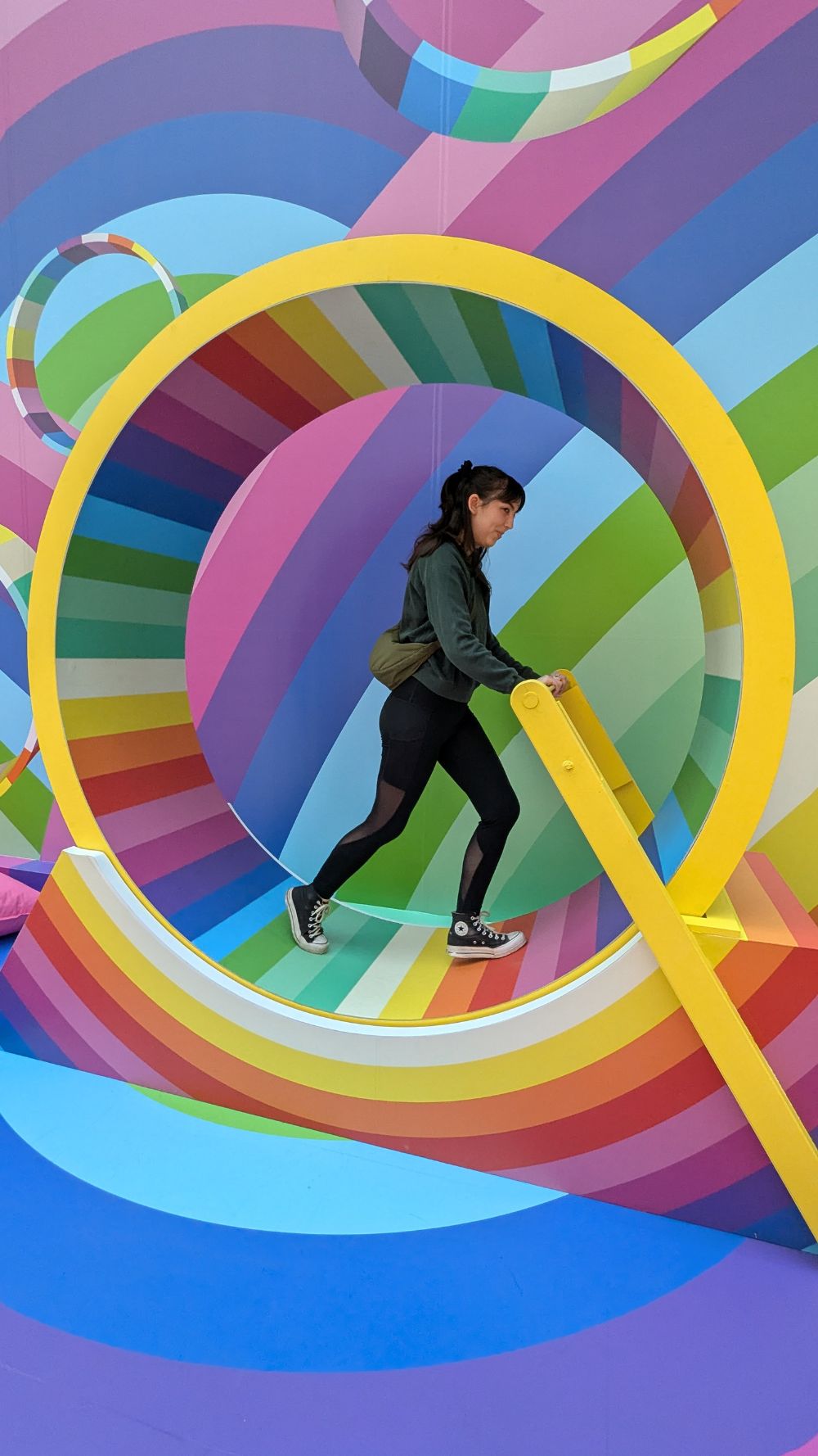 A racer walking through a colourful downtown art installation