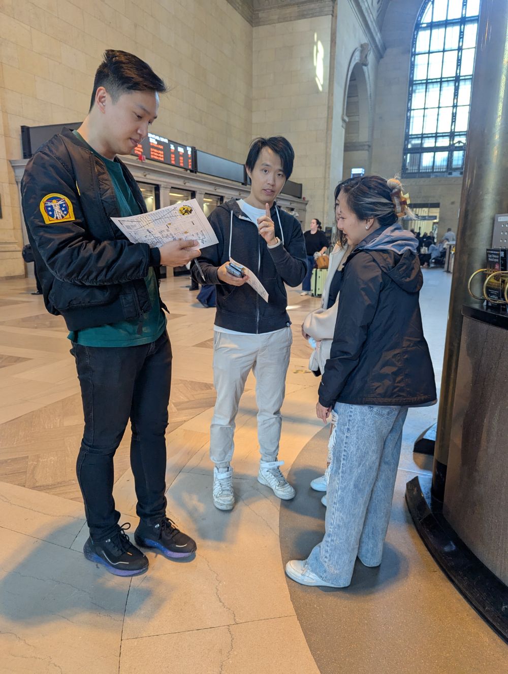 A team huddled over their paper map inside Union Station's Great Hall